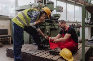 Female worker helping her colleague after factory accident