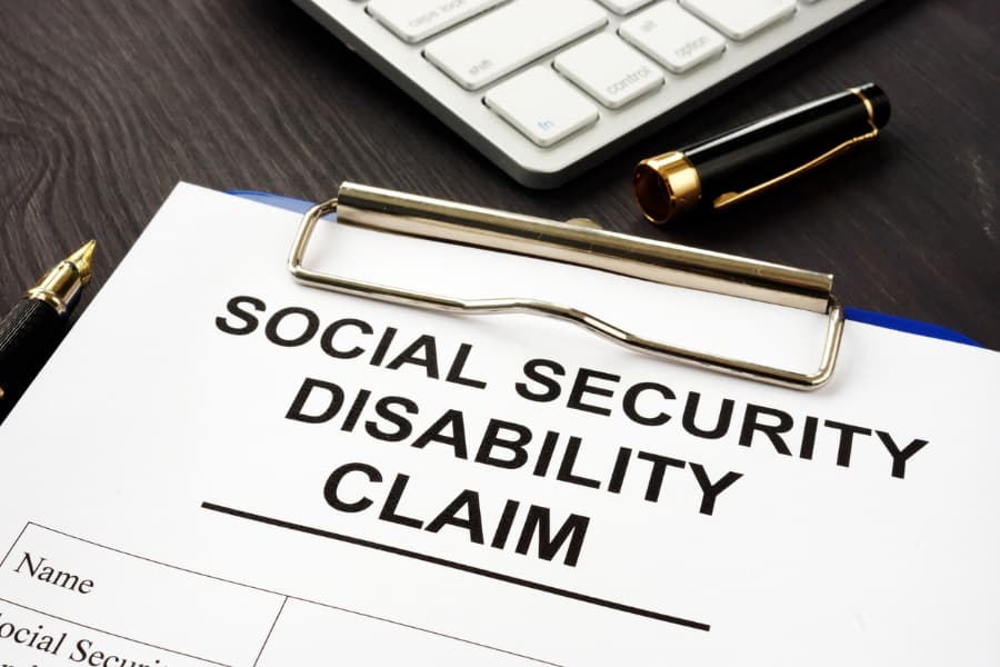 Close-up of Social Security Disability claim form with a pen and calculator