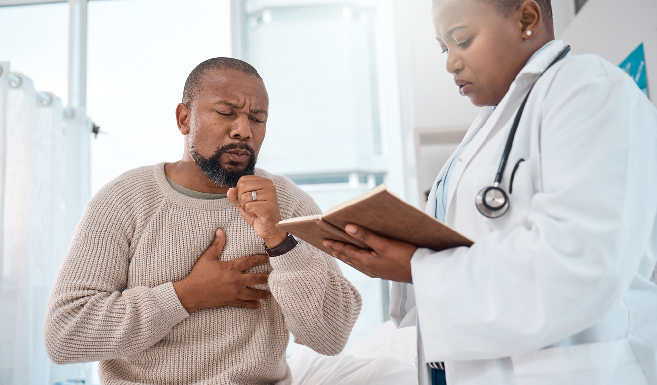 Man coughing and holding his chest during a medical appointment