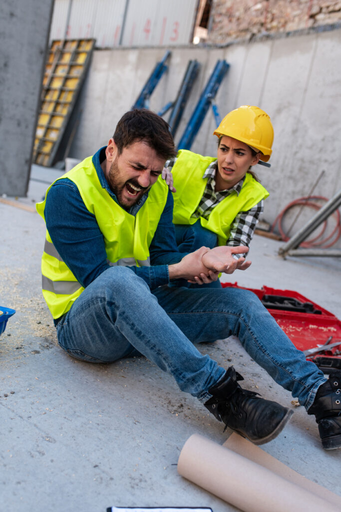 Female construction worker helping a coworker with an injured wrist