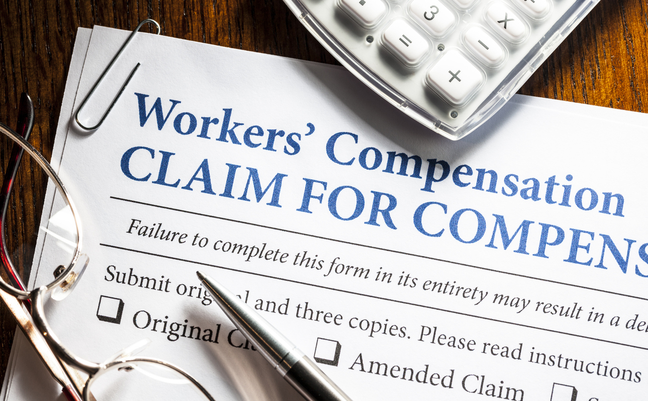 Printed workers’ compensation form with pen on a table