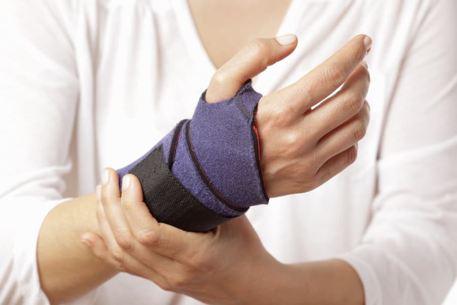 Close-up of woman holding her wrist with brace on it